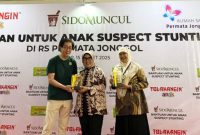BANTUAN - Direktur PT Industri Jamu dan Farmasi Sido Muncul Tbk DR (HC) Irwan Hidayat secara simbolis menyerahkan bantuan program CSR Sido Muncul untuk anak-anak suspect stunting di RS Permata Jonggol. (ist/tya)