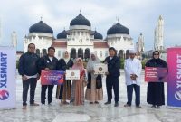 - WAKAF ALQURAN- Director & Chief People Officer XLSMART, Jeremiah Ratadhi, (kedua dari kiri) saat Penyerahan Wakaf Al-Quran yang dilaksanakan di halaman Masjid Raya Baiturrahman, Jl. Moh. Jam No.1, Kp. Baru, Kec. Baiturrahman, Kota Banda Aceh, Aceh. Jum’at (20/6/2025). Foto : Dok.XLSmart/metrojateng.id